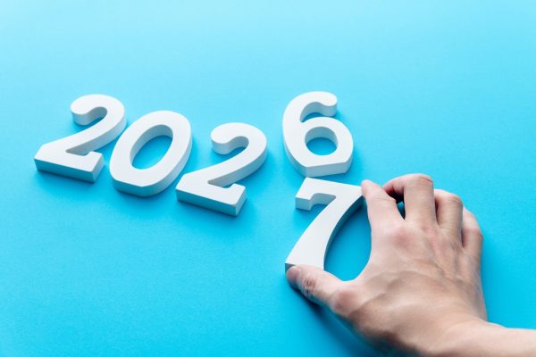 Hand changing year 2026 to 2027 in blue background